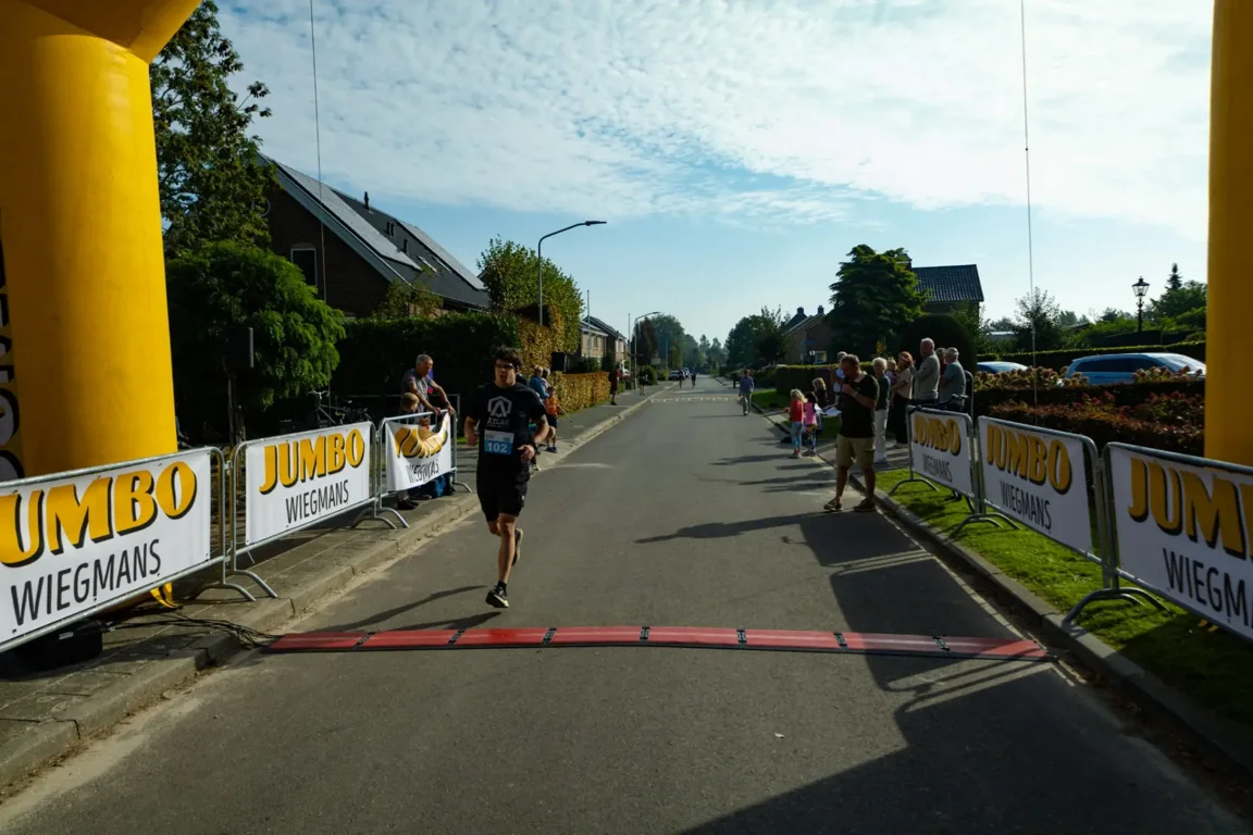 Rick A in zijn Atlas Training-shirt bij de finish van een hardloopwedstrijd